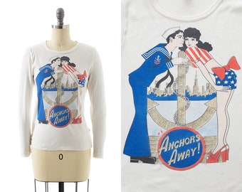 Vintage 1980s Top | 80s Sailor Pin Up Novelty Print 1940s Style Long Sleeve White Glitter USA New York City Graphic T-Shirt (x-small/small)