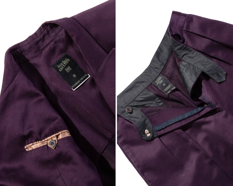 Pu&ograve; includere: Una giacca di completo e pantaloni abbinati di colore viola con un dettaglio di tasca marrone. La giacca ha un'etichetta che recita "Jean Paul Gaultier Homme" e "34".