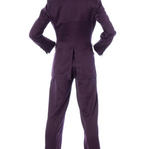 Pu&ograve; includere: Un completo viola con giacca e pantaloni. Il completo &egrave; su un manichino bianco.