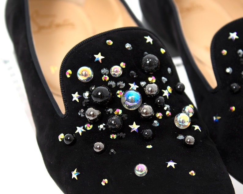 May include: Black suede loafers with a star and iridescent bead embellishment.