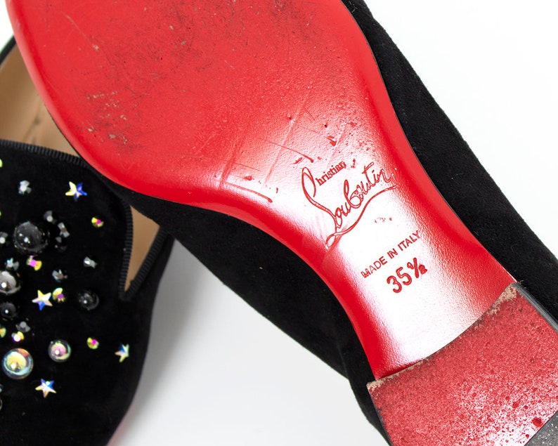 May include: Black suede loafers with a red leather sole and a star-shaped embellishment. The sole is marked "Christian Louboutin" and "Made in Italy 35 1/2".