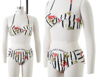 May include: A white and black striped bikini with a floral print. The top has a halter style and the bottom is a high-waisted style.