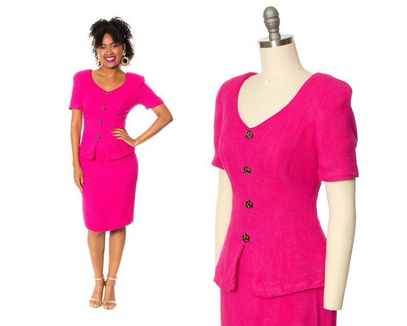 May include: A hot pink skirt suit with a short-sleeved jacket and a pencil skirt. The jacket has a V-neckline and buttons down the front. The skirt has a high waist and a fitted silhouette.