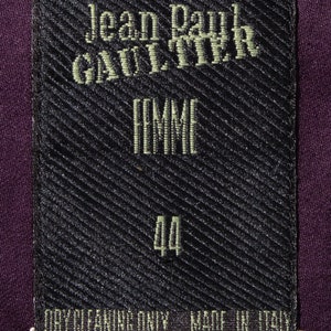 Pu&ograve; includere: Etichetta nera con testo bianco che recita "Jean Paul GAULTIER FEMME 44 PULIZIA A SECCO SOLO PRODOTTO IN ITALIA".