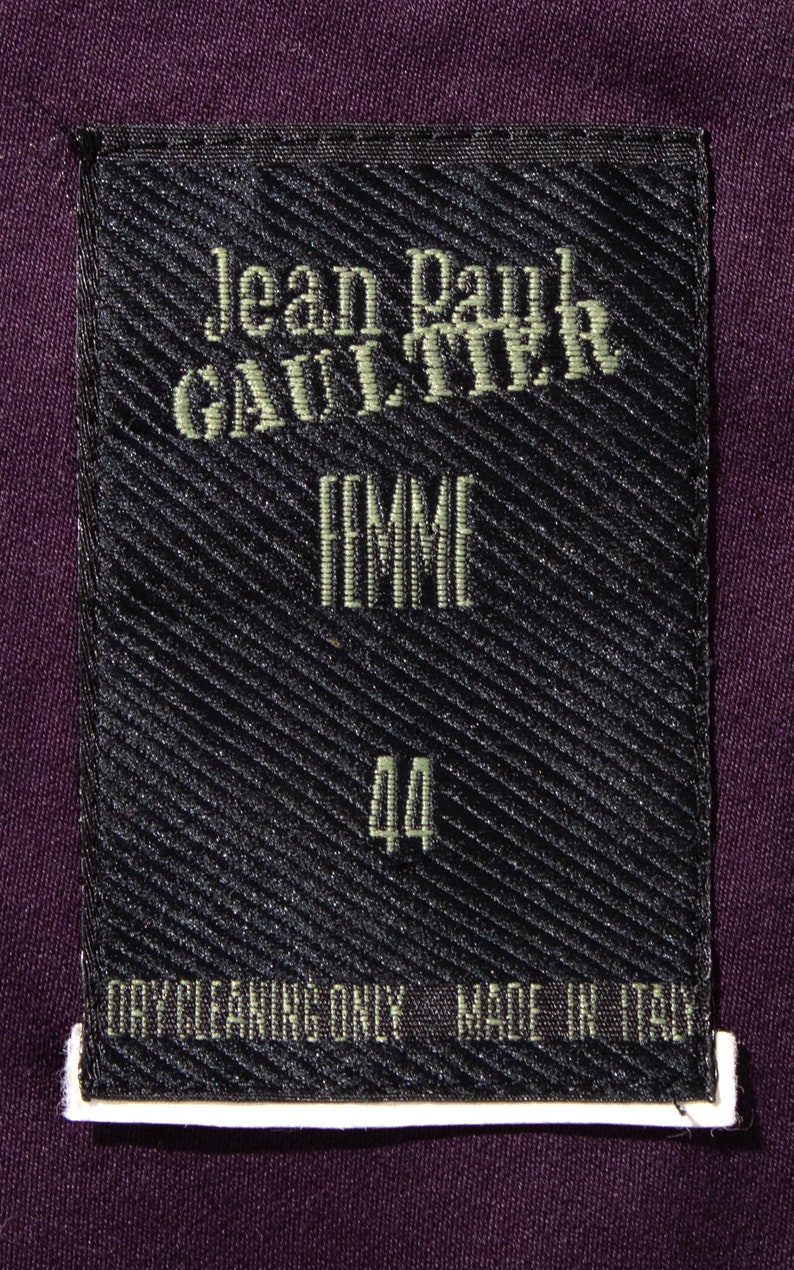 Pu&ograve; includere: Etichetta nera con testo bianco che recita "Jean Paul GAULTIER FEMME 44 PULIZIA A SECCO SOLO PRODOTTO IN ITALIA".