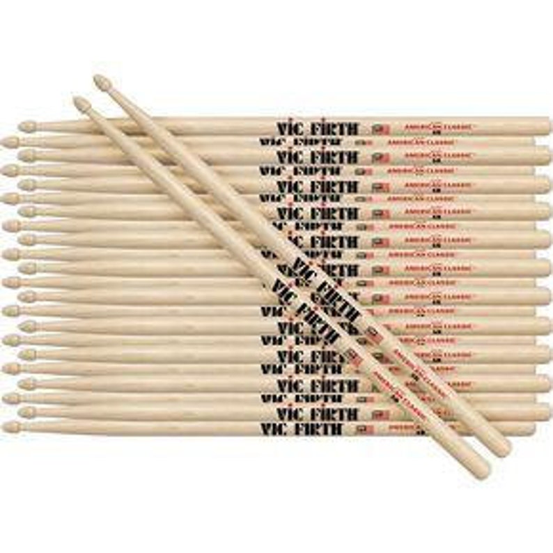 May include: A pack of 24 wooden Vic Firth American Classic 5A drumsticks. The sticks are natural wood with black lettering and a red logo.