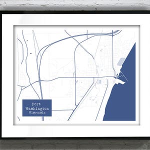 May include: Framed map print of Port Washington, Wisconsin, featuring a detailed blue and white cartographic design. The map highlights the city's layout, roads, and waterfront area, with the city name in a blue rectangle.