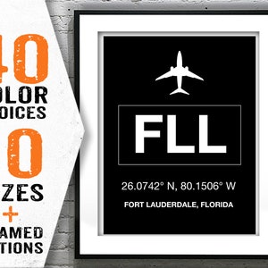 May include: A black and white airport code sign with the letters "FLL" and the coordinates "26.0742&deg; N, 80.1506&deg; W" below. The text "FORT LAUDERDALE, FLORIDA" is below the coordinates. A white airplane icon is above the code.