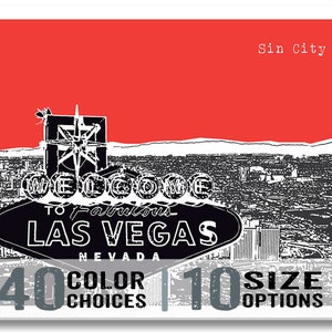 May include: Black and white illustration of the Las Vegas sign with the text "Welcome to Fabulous Las Vegas, Nevada". The sign is set against a red background with a cityscape in the background. The text "Sin City" is in the top right corner of the image. The text "40 Color Choices" and "10 Size Options" is at the bottom of the image.