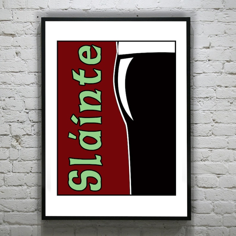 Puede incluir: Una impresi&oacute;n enmarcada con un fondo rojo y la palabra "Sl&aacute;inte" en texto verde. Una silueta negra de un vaso de cerveza est&aacute; en el lado derecho de la impresi&oacute;n.