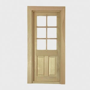 May include: A miniature wooden door with a six-pane window at the top and two panels at the bottom. The door is set within a matching wooden frame. The wood has a natural, light colour.