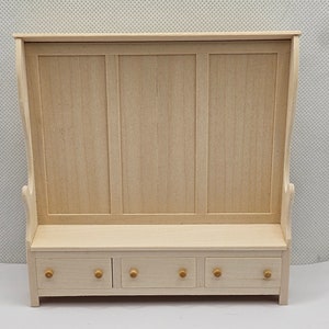 Può includere: Una panca in legno con schienale alto e tre cassetti. La panca è in legno chiaro e ha un design semplice.