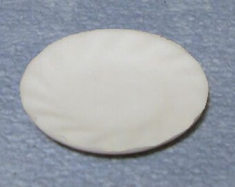 May include: A white ceramic plate with a slightly rippled surface.