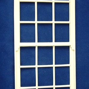 May include: White wooden window frame with 16 panes. The frame is made of wood and has a simple design.