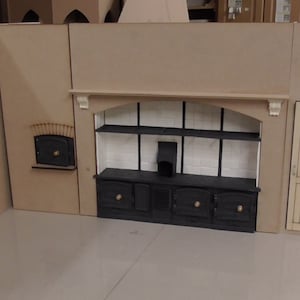 May include: A dollhouse kitchen set featuring a black stove, white tiled backsplash, and a small oven. The set is crafted from wood and painted in neutral tones.