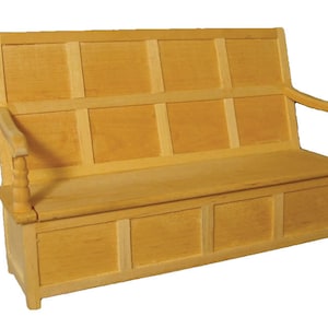 Può includere: Una panca in miniatura in legno chiaro. La panca presenta uno schienale con pannelli rettangolari, braccioli e un vano portaoggetti sotto la seduta. Il design ricorda i mobili classici.