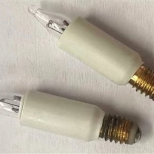 Puede incluir: Dos pequeñas bombillas de vidrio transparente con bases de cerámica blanca y extremos de rosca de latón.