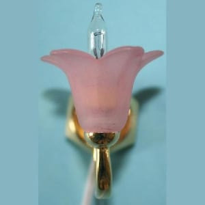 Puede incluir: Una lámpara de pared de cristal rosa en forma de flor con una base de metal dorado y una bombilla transparente.