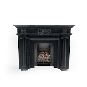 Puede incluir: Chimenea de hierro fundido negro con una parte superior decorativa y columnas acanaladas. La chimenea tiene una rejilla de metal negro y un interior de ladrillo.