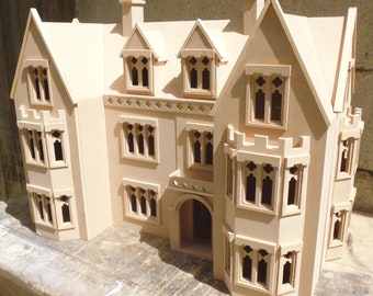 May include: A wooden model of a large, multi-story house with a gabled roof, multiple windows, and a front entrance. The model is made of unfinished wood and is ready to be painted.