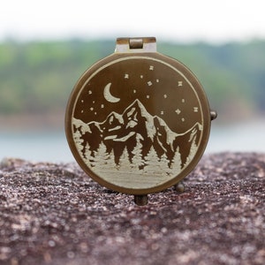 engraved compass with mountain moon and stars