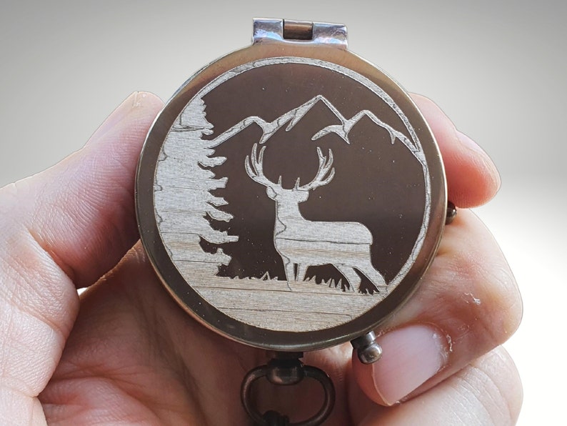 deer with mountain and trees engraved compass