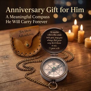 Engraved antique brass compass open to show working dial and inside message with a brown leather pouch engraved BDR beside it on a wooden surface