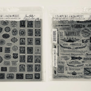 May include: Two sheets of clear rubber stamps with black ink. The left sheet has a collection of 64 small stamps with various designs, including letters, numbers, and symbols. The right sheet has 12 larger stamps with designs related to mail and postage. The text "Stampers Anonymous" appears on both sheets.