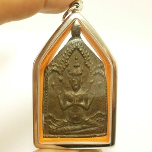 May include: A silver pendant with a bronze amulet depicting a deity with multiple arms. The amulet is framed in a silver and orange border.