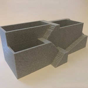 May include: A gray 3D printed organizer with multiple compartments and a unique staircase design.