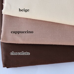 May include: Three fabric swatches in different shades of brown. The top swatch is beige, the middle swatch is cappuccino, and the bottom swatch is chocolate.