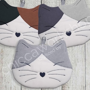 May include: Cat-shaped kitchen pot holders in various colors: black and brown, gray and brown, and gray. Each has a white face with a heart nose and whiskers. They hang from silver hooks on a light wood background.