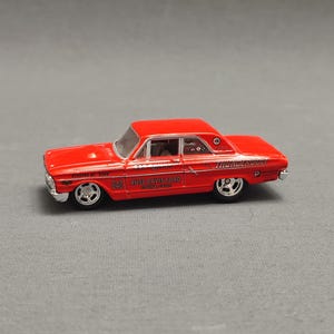 Puede incluir: Modelo de coche de fundición rojo Ford Mustang 1967 con "THUNDERBOLT" y "RUSS DAVIS FORD" impresos en el lateral. El coche tiene ruedas negras y un interior negro.