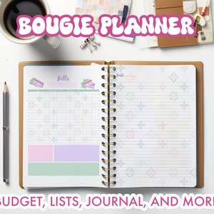 Puede incluir: Una agenda rosa y blanca con el texto "BOGIE PLANNER" en la parte superior. La agenda tiene un patrón colorido de estrellas y un patrón de cuadrícula en las páginas. El texto "BUDGET, LISTS, JOURNAL, AND MORE" está en la parte inferior de la imagen.