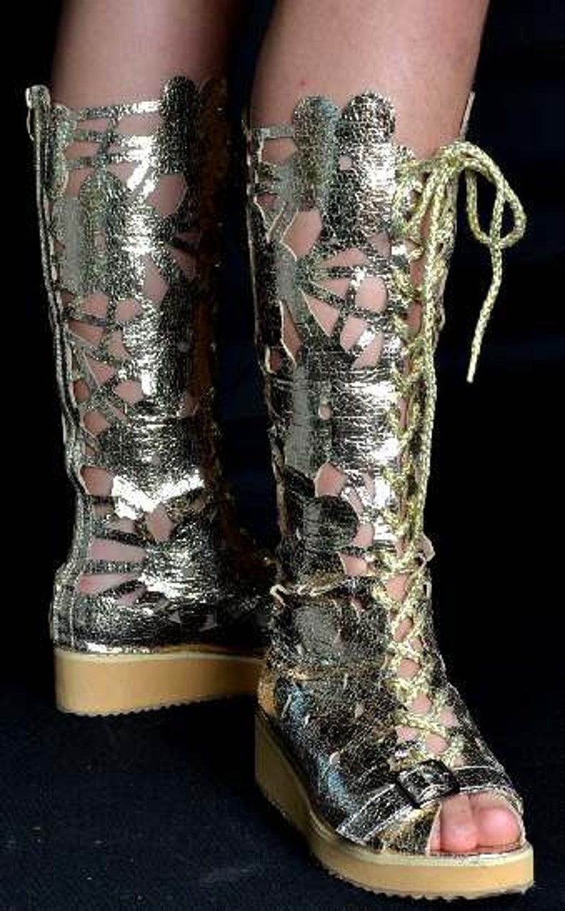 May include: Gold-colored cut-out boots with a lace-up design and a thick platform sole.