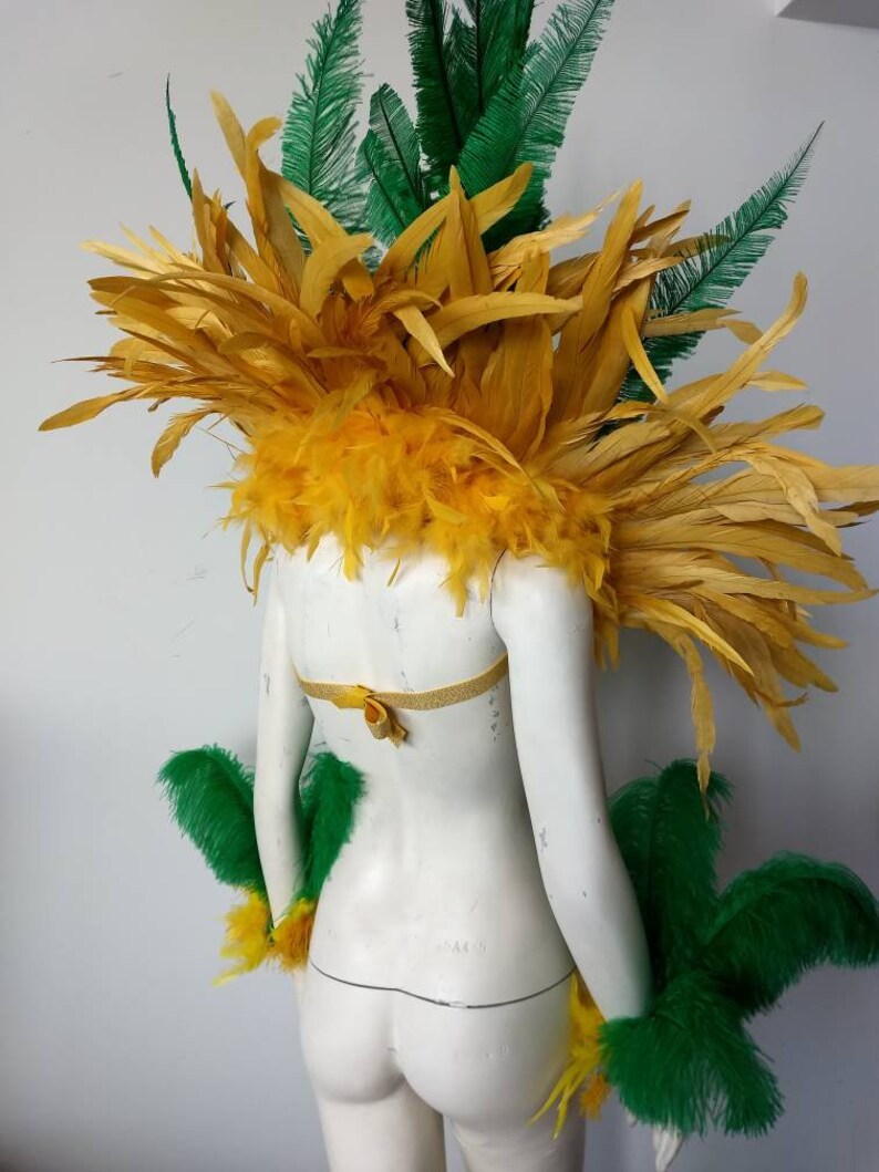 May include: A yellow and green feather costume with a yellow feather headpiece and green feather arm cuffs.