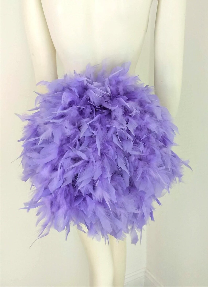 Puede incluir: Una falda de plumas de color lavanda. La falda est&aacute; hecha de plumas suaves y esponjosas y es perfecta para agregar un toque de fantas&iacute;a a cualquier atuendo.