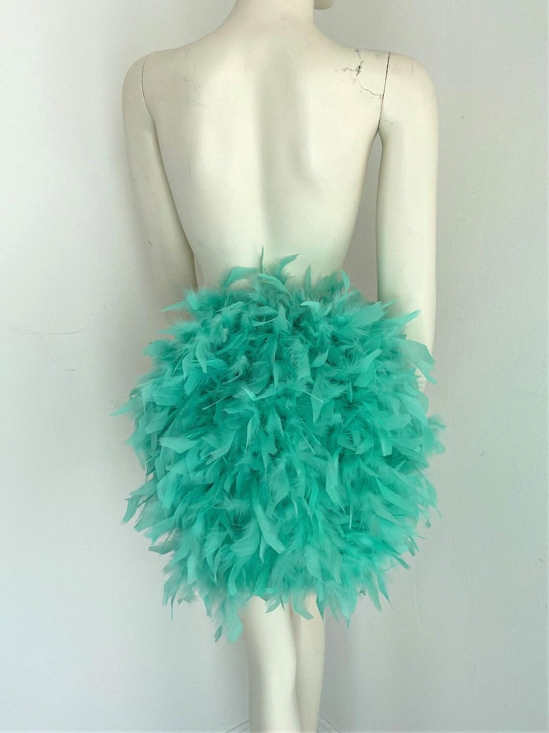 Puede incluir: Una falda de plumas turquesa. La falda est&aacute; hecha de un material suave y esponjoso, perfecta para un disfraz o una fiesta.