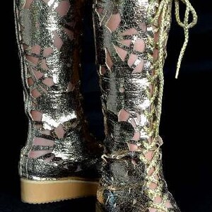 May include: Gold-colored cut-out boots with a lace-up design and a thick platform sole.