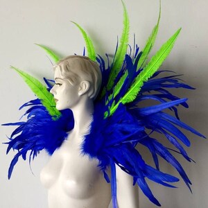 May include: A blue and green feather shoulder piece. The piece is made of long, flowing feathers in shades of blue and green. The feathers are arranged in a way that creates a dramatic and eye-catching look.