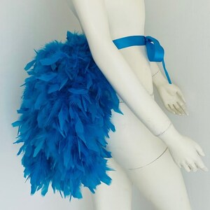 Puede incluir: Un boa de plumas azul brillante atado a la cintura con una cinta azul a juego. El boa es completo y esponjoso, creando un look dram&aacute;tico y llamativo.