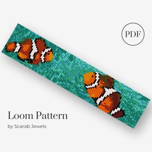 Op de afbeelding: Een loom kralenpatroon met twee oranje en witte clownvissen die zwemmen in een turquoise blauwe oceaan. Het patroon is gelabeld "Loom Pattern by Scarab Jewels" en bevat een PDF-pictogram.