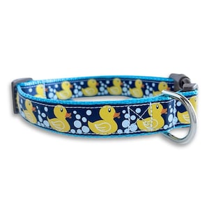 Könnte beinhalten: Ein blaues und marineblaues Hundehalsband mit einem sich wiederholenden Muster aus gelben Gummienenten und weißen Blasen.