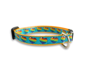 Op de afbeelding: Een turquoise blauwe hondenriem met een gele rand en een regenboog hart print.