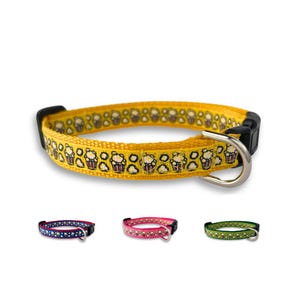 May include: Yellow dog collar with a popcorn print. The collar has a black buckle and a silver D-ring. The collar is shown with three other color options: blue, pink, and green.