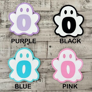 Op de afbeelding: Vier spookvormige uitsnijdingen met de letter "O" in het midden. De spoken zijn in de kleuren paars, zwart, blauw en roze.