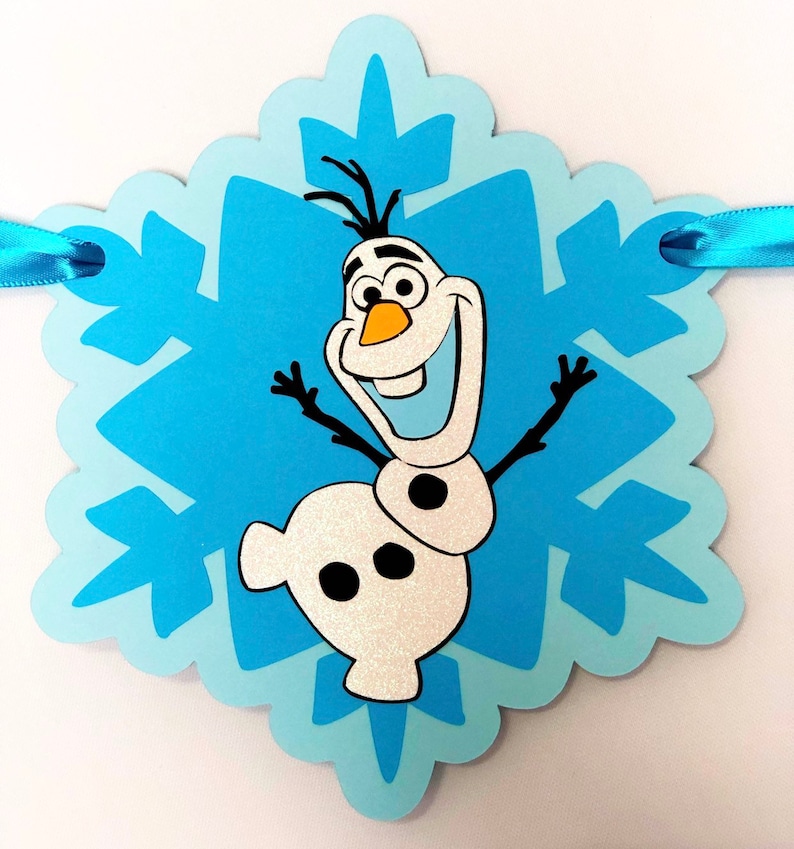 Pu&ograve; includere: Uno striscione a forma di fiocco di neve azzurro con il personaggio Olaf del film Frozen. Olaf sorride con le braccia tese. Lo striscione ha un nastro azzurro per appenderlo.