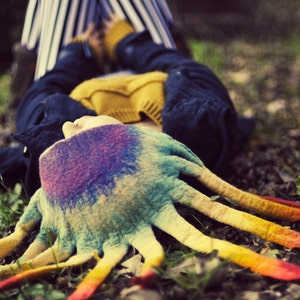 Op de afbeelding: Een kleurrijke, veelkleurige, handgebreide octopusmuts met lange tentakels. De muts is gemaakt van zacht, pluche garen en heeft een uniek, grillig ontwerp.
