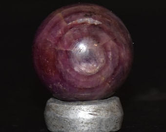 Rare large eye ruby corundum sphere with antique aluminum stand