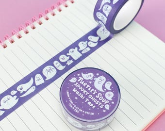 May include: A roll of purple washi tape featuring a pattern of white cartoon ghosts. The label on the roll reads Turtle's Soup Spooky Ghosts Washi Tape 15mm x 10m / 0.59 in x 10.9 yd. A strip of the tape is unrolled across a lined notebook page.